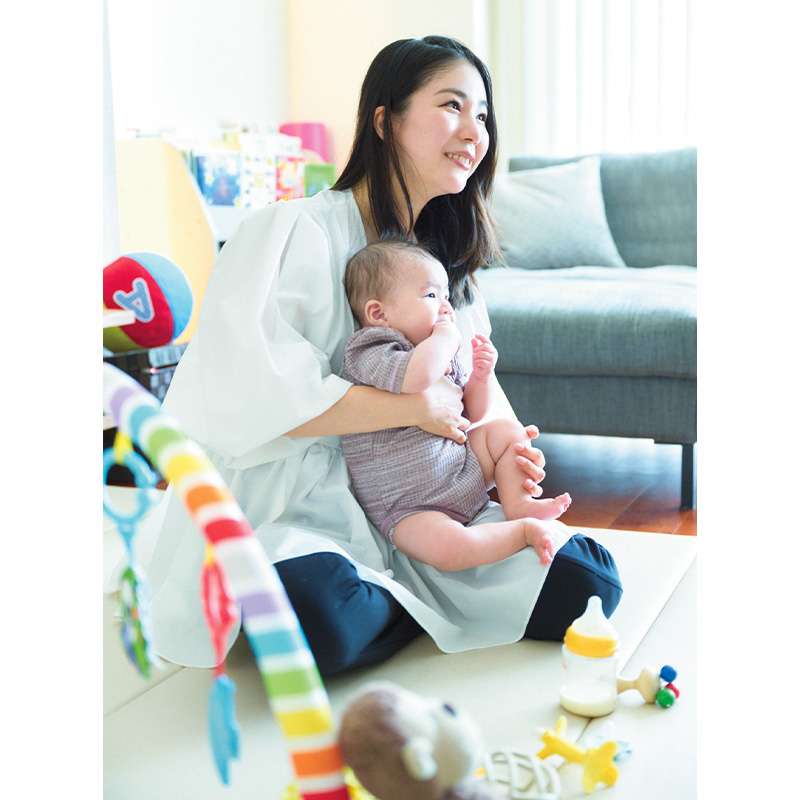 自宅で赤ちゃんを膝に乗せる外資系会社勤務のママ