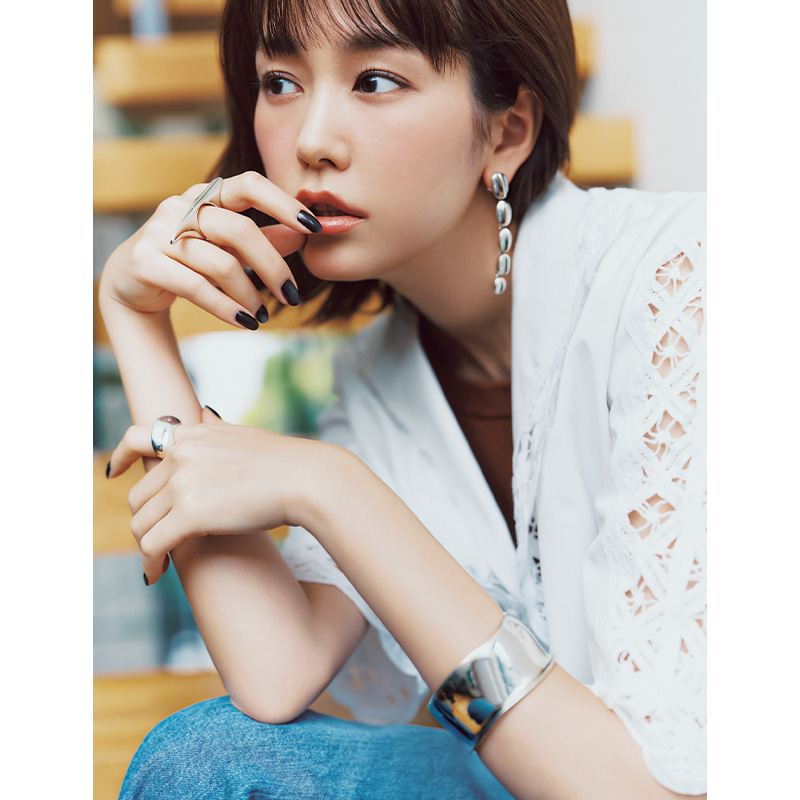 白のレースシャツとデニムにシルバーのバングルとピアスとリングをつけた桐谷美玲さん