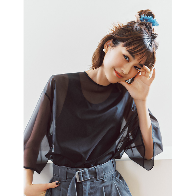 黒のシアートップスとベルト付きタックパンツを着て髪をシュシュでハーフアップした桐谷美玲さん