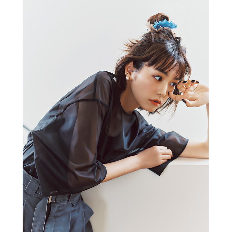 黒のシアートップスとベルト付きタックパンツを着て髪をシュシュでハーフアップした桐谷美玲さん