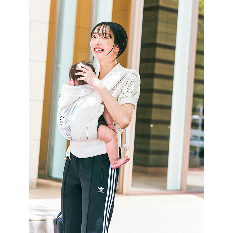 衿つきサマーニットとアディダスのトラックパンツのコーデで赤ちゃんを抱っこするママ