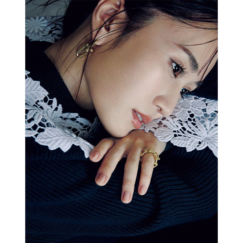 レース衿がついたニットにティファニーハードウェアのピアスとリングを合わせた前田敦子さん