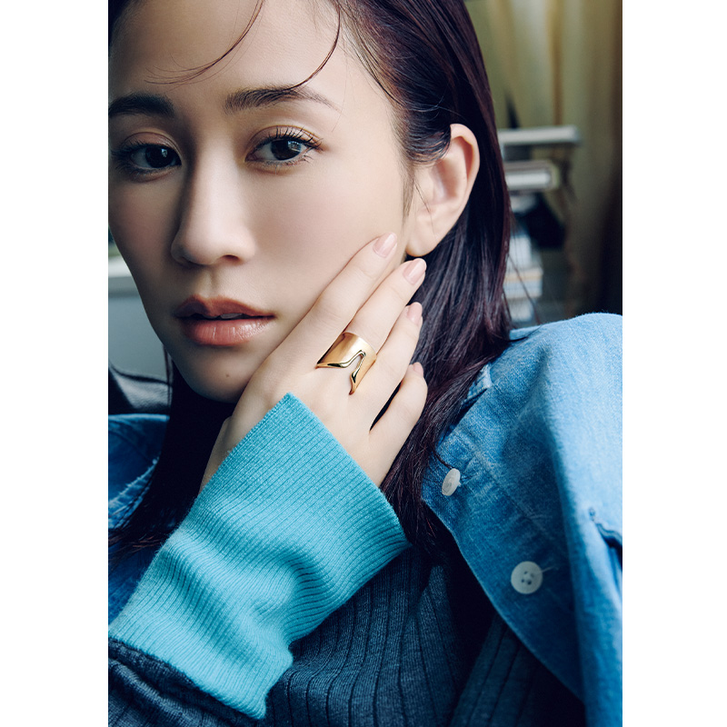 ブルーのニットとデニムシャツの手元にティファニーのエルサ・ペレッティ™　スプリット リングをつけた前田敦子さん