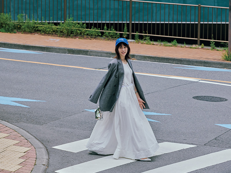 白のタンクトップとスカートにチェック柄ジャケットを羽織ってブルーのキャップを被った桐谷美玲さん