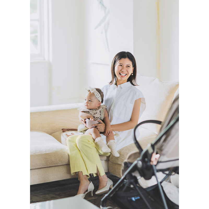 ミラオーウェンのブラウスとレモンイエローのデニムを着て赤ちゃんを抱っこするVERY読者