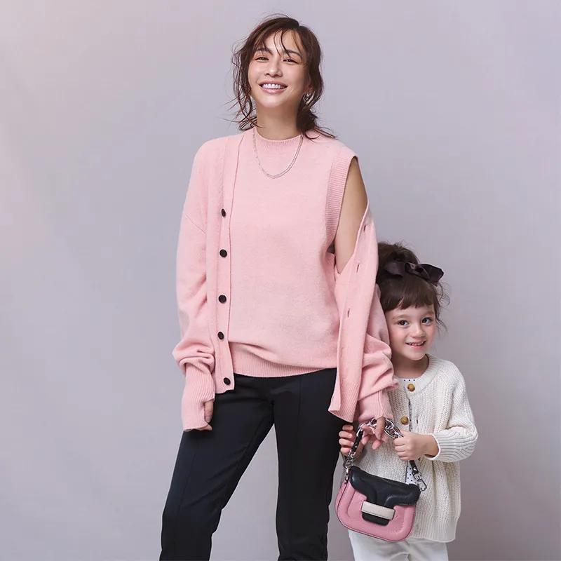 ピンクのアンサンブルに黒のパンツのコーディネート