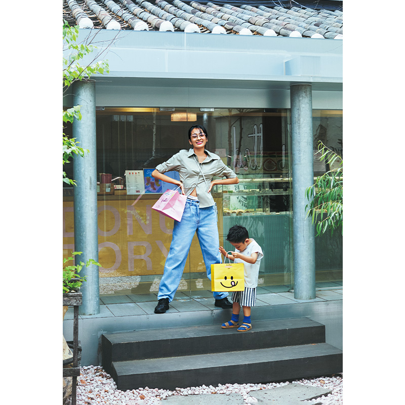 シャツ×デニムの木佐貫まやさんと子どもモデルがショップの前に立っている画像