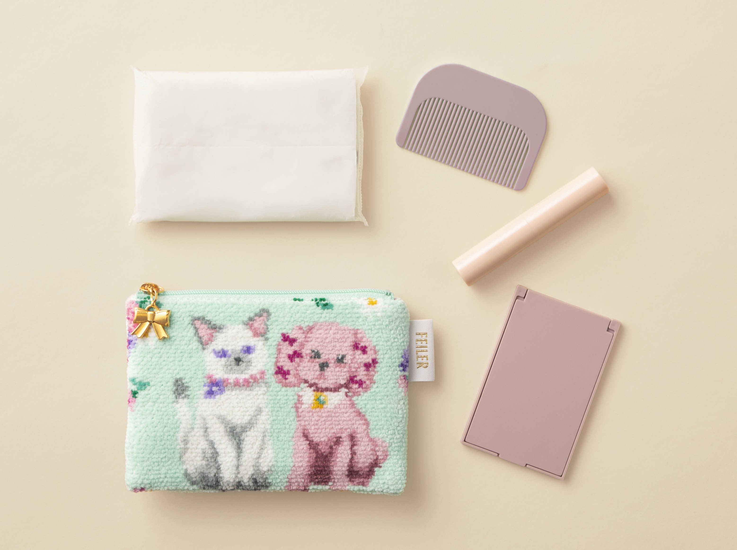 水色に犬と猫の柄のシュニール織のティッシュポーチと中身例（周囲にティッシュやコーム）