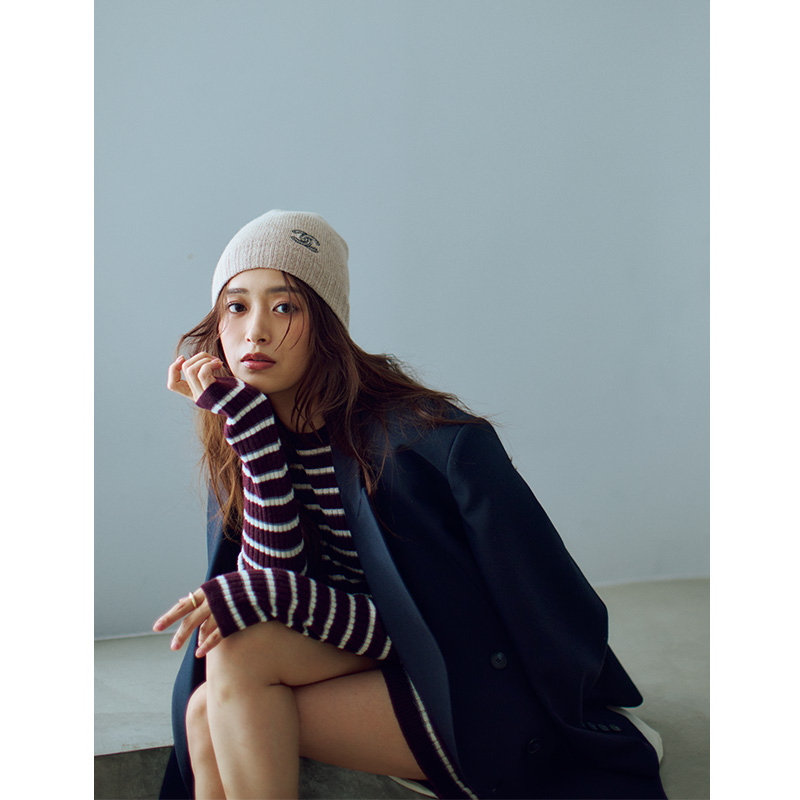 ボーダニットにジャケットを肩掛けして私物のシャネルのニット帽を被った近藤千尋さん