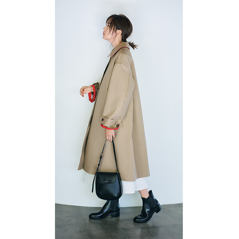 ベージュのコートに黒のバッグとレインブーツを合わせた桐谷美玲さん