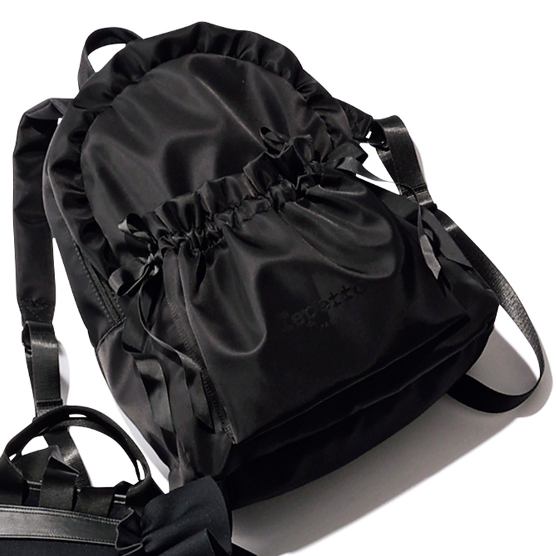 艶のある黒ナイロンにギャザーやフリルの甘デザインが効いたレペットのリュック