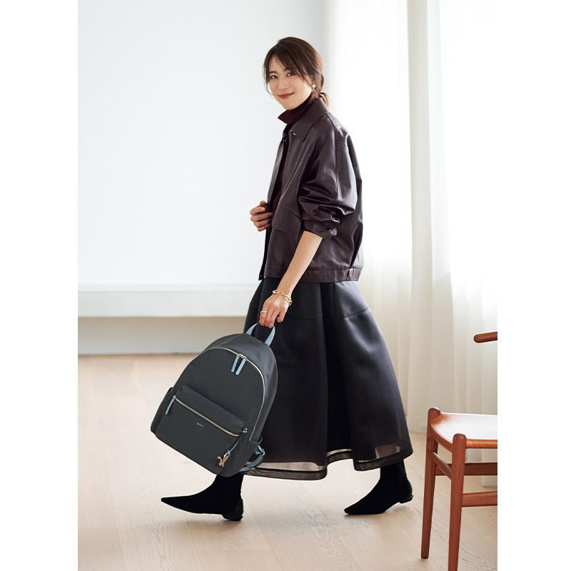 ブルゾンとスカートにチャコールのナイロンボディのリュックを持ったキレイめコーデ