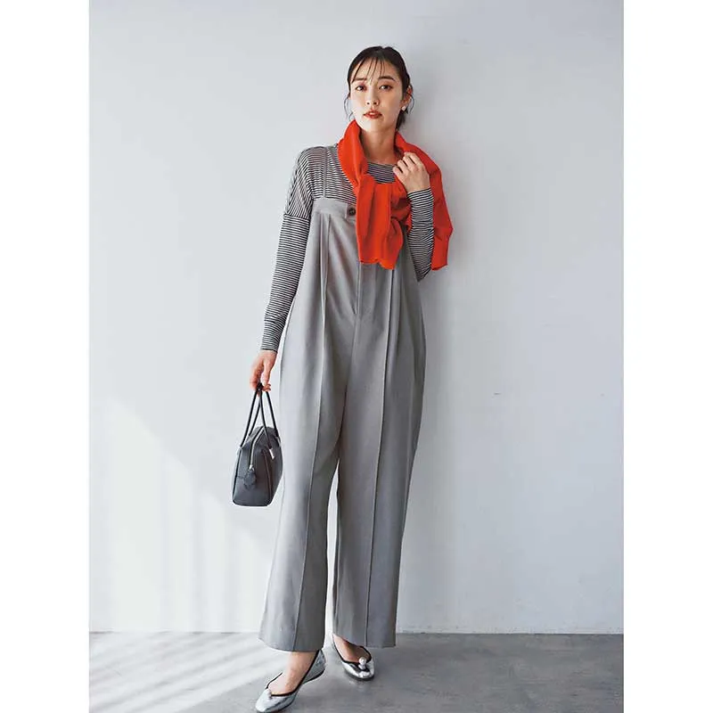 オールグレーのロンパースに差し色のカーディガンを肩掛けしたコーディネート