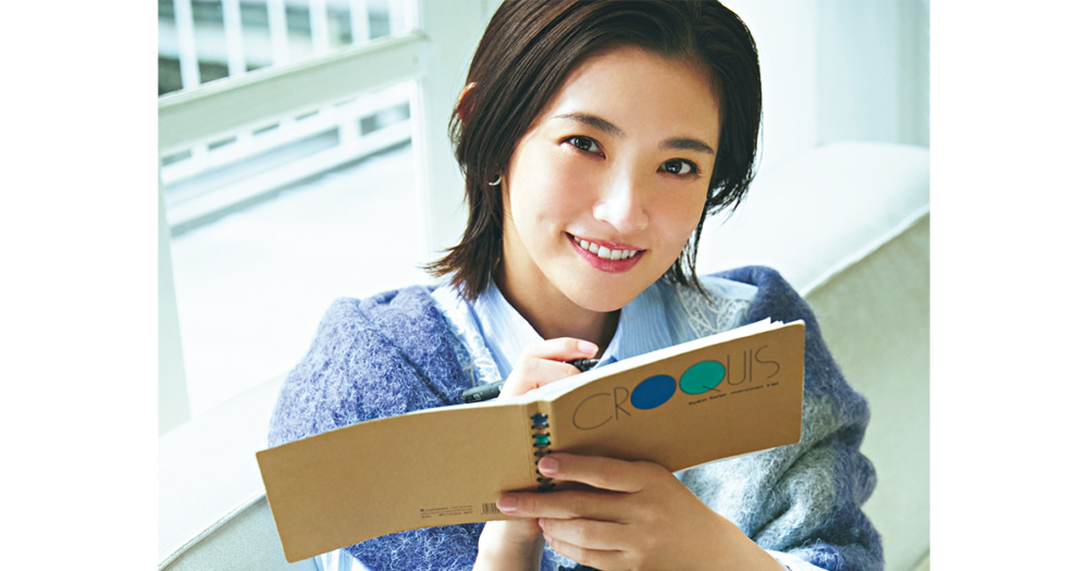 ノートとペンを手に微笑む星野真里さん