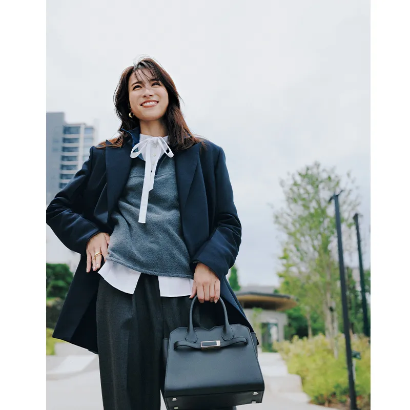 リボンタイ付き白ブラウスにグレーのフリース、ジャケットのパンツコーデ