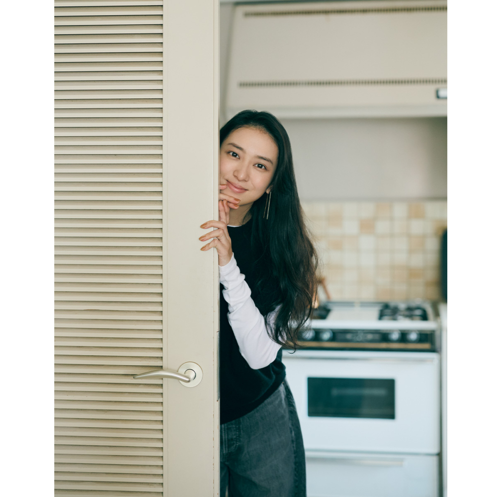 カットソーとデニムにデニムを合わせたスタイルで扉から覗く武井咲さん