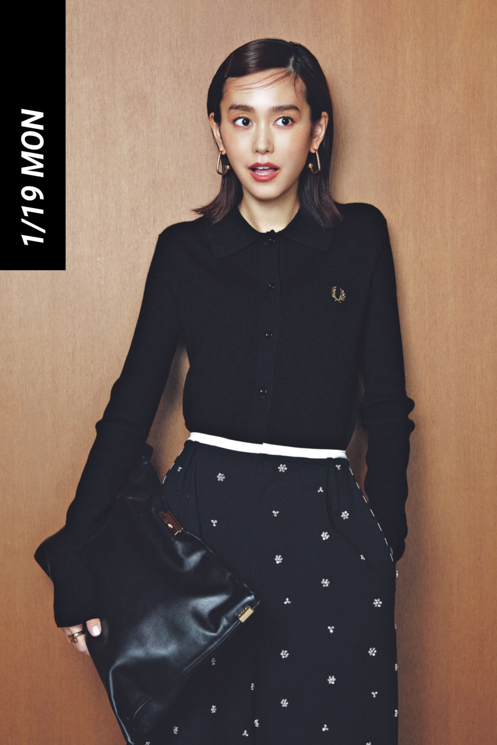 ポロニットと柄パンツにゴールドのアクセサリーや大きなクラッチバッグを合わせたコーデ