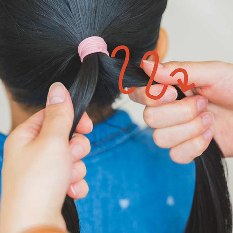 ポニーテールを中央で2つに割って右手に取った毛束を時計回りにぐるぐるとねじる。