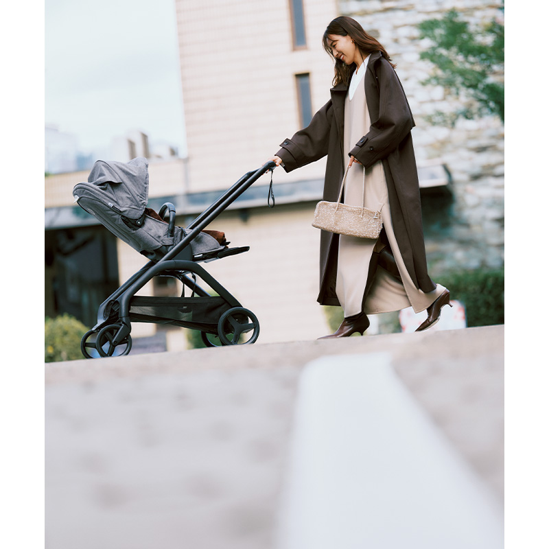 白ブラウスにベージュのジャンパースカートを重ねてアウターを羽織った子連れお出かけコーデ