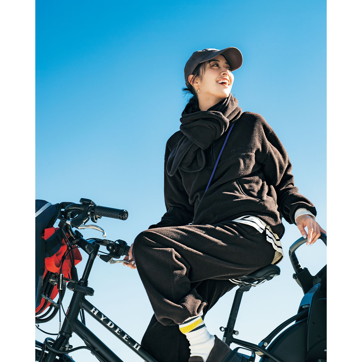 トゥデイフルのフリースプルオーバーとパンツのセットアップを着た自転車コーデ