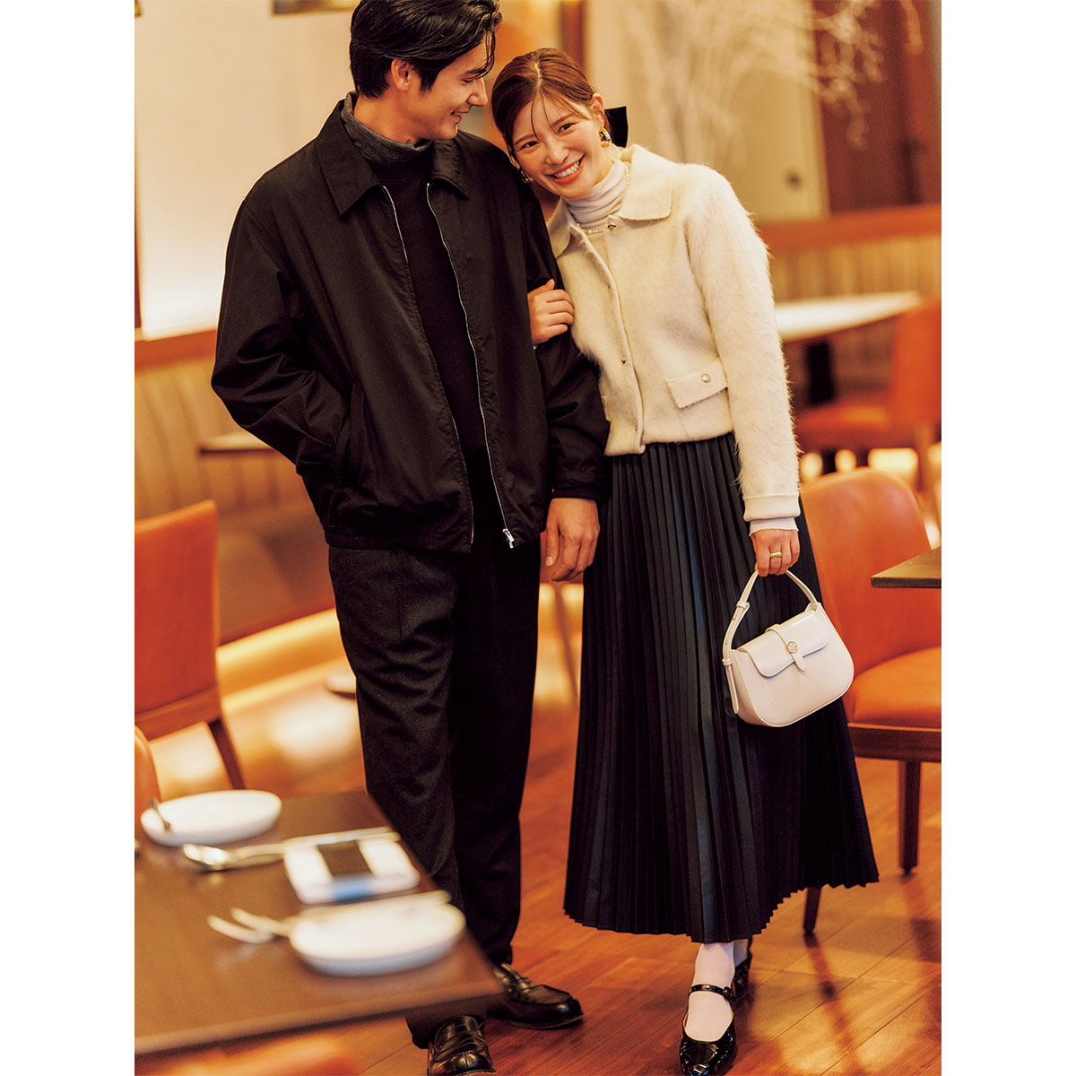 衿つきカーディガンとフェイクレザープリーツスカートにミニバッグやメリージェーンを合わせた夫婦デートコーデ