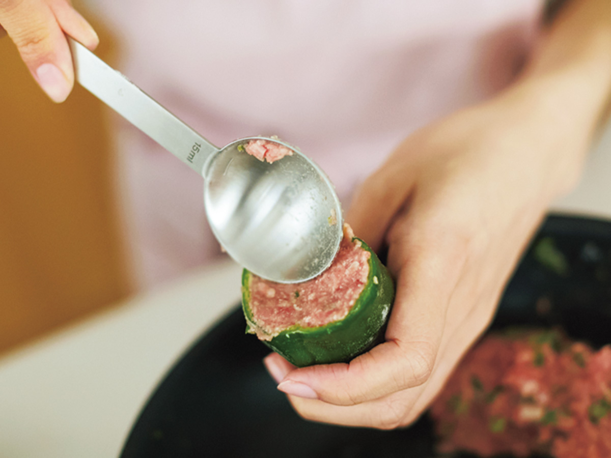 ピーマンに肉だねを詰めているところ