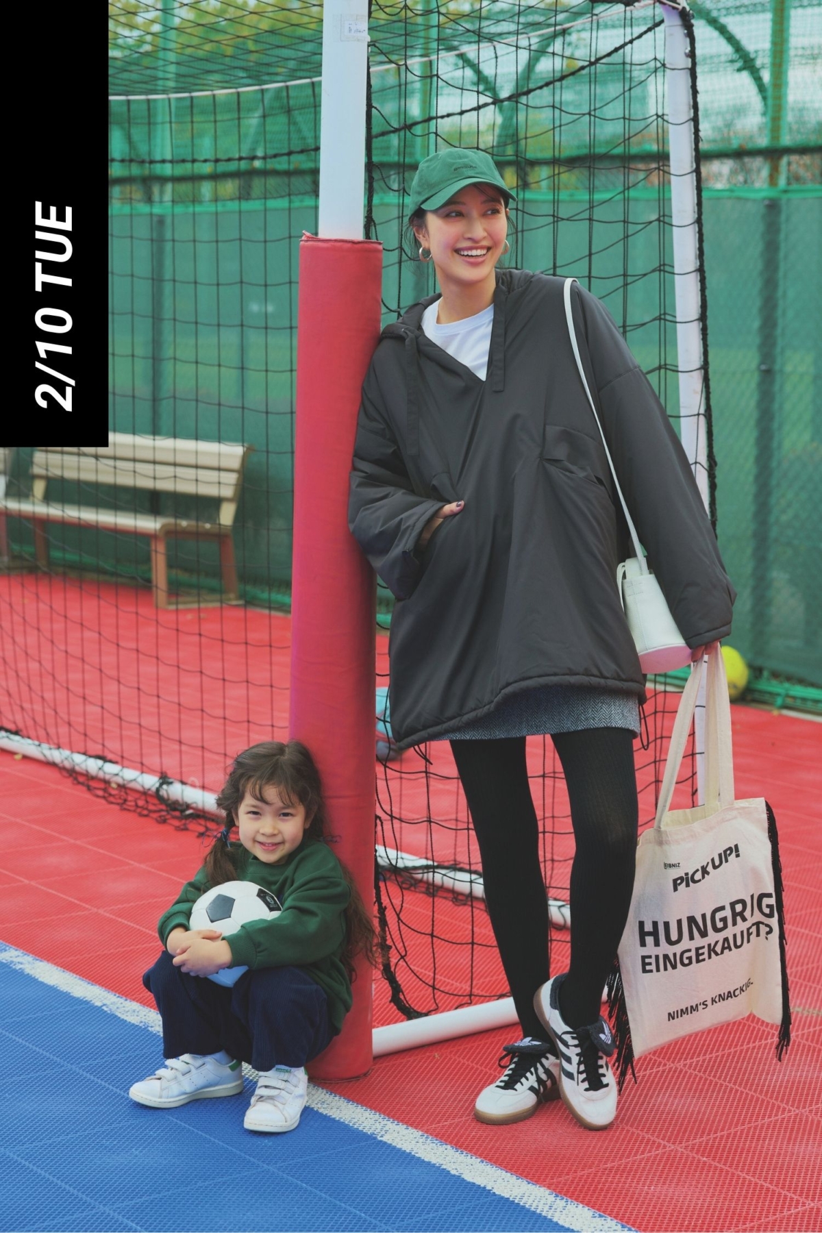 白Tとミニスカートに黒の黒のアノラックパーカーを着て黒タイツとアディダスのフラップタンのついたスニーカーを合わせたママコーデ