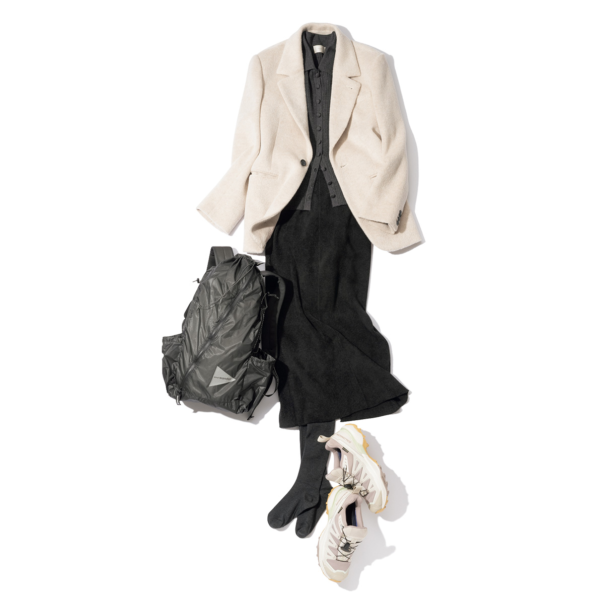 白ジャケットと黒のタイトスカートにサロモンのスニーカーとアンドワンダーのリュックを合わせたスタイル