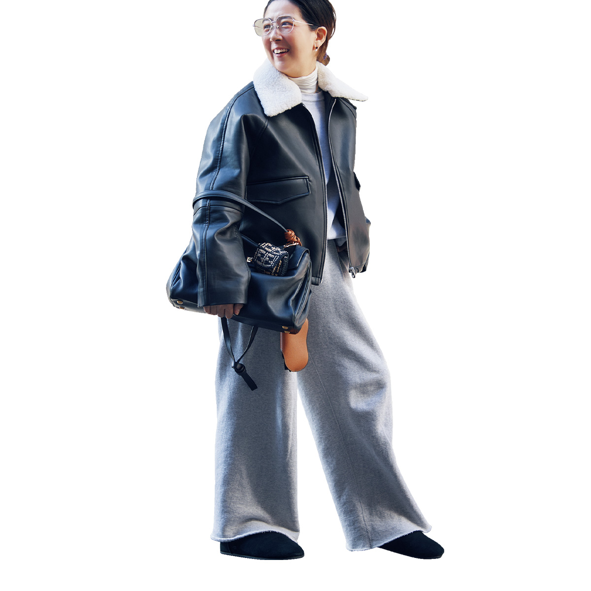 レザージャケットとスウェットパンツにラフにバレンシアガのロデオを持ったスタイリストの竹村はま子さん