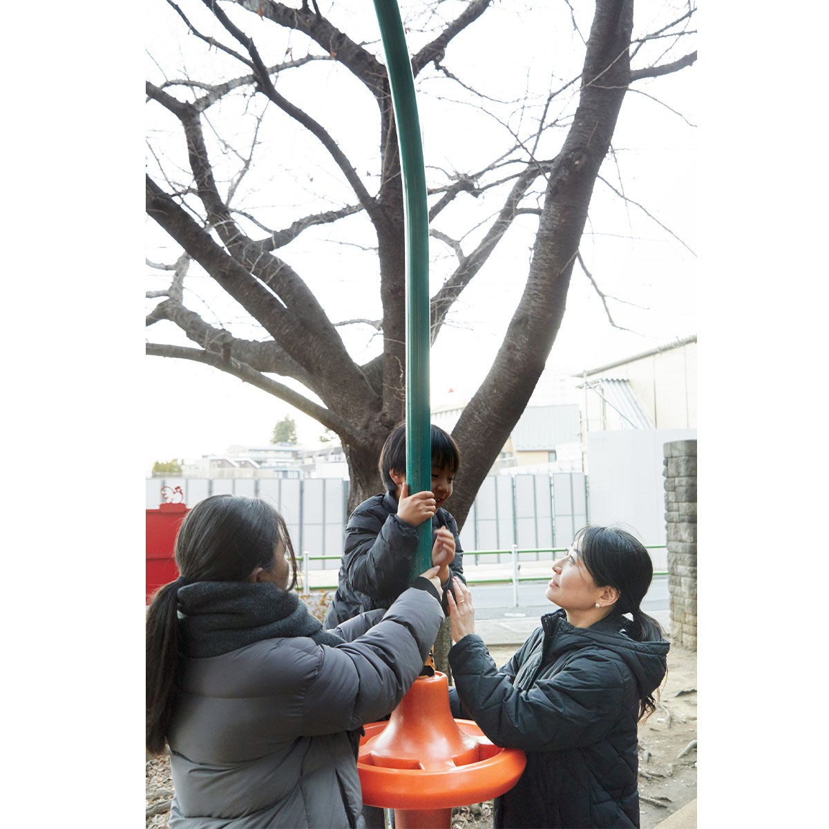 遊具で遊ぶ溝上さんの息子さんと見守る溝上さんとベビーシッターさん