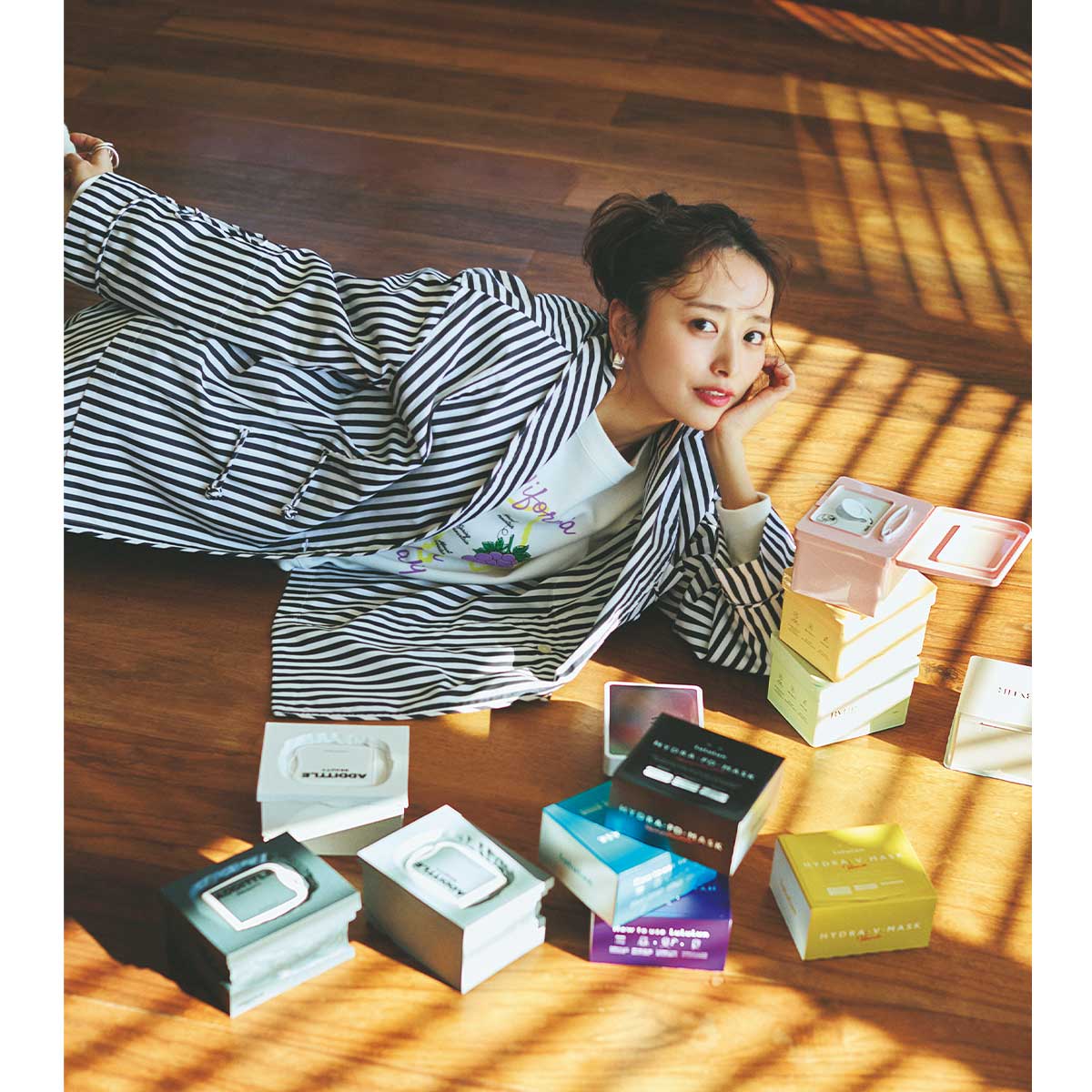 いろんな種類のシートマスクに囲まれて横になった近藤千尋さん