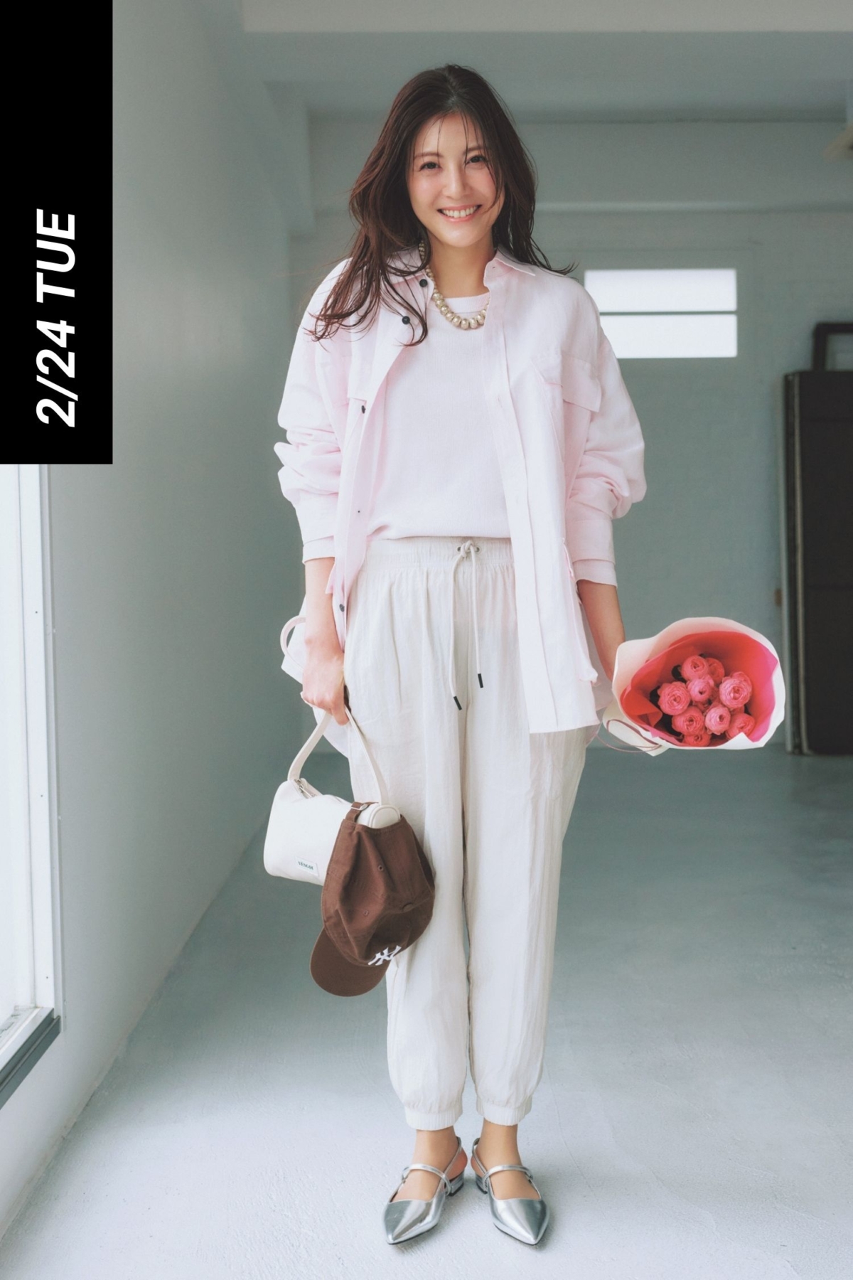ピンク色のシャツと白のインナーに白のスポーティなパンツを合わせた淡色コーデ