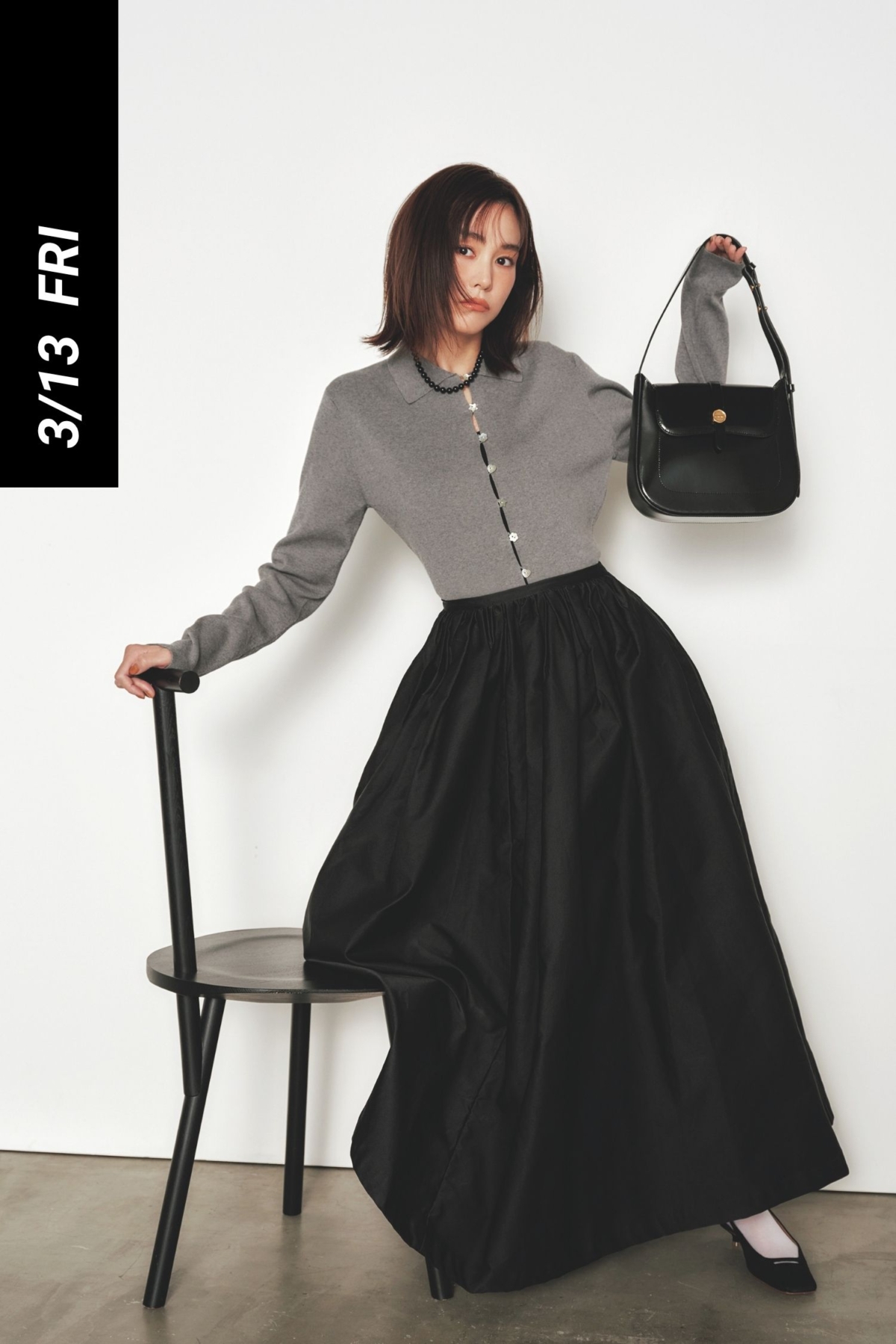 グレーのポロカーデと黒のボリュームスカートに黒バッグとパンプスを合わせた桐谷美玲さん