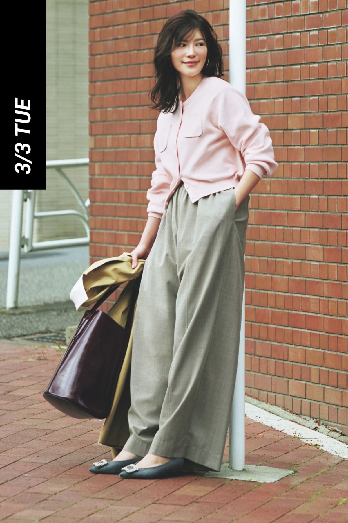 ピンクのポケット付きカーデにグレーのスラックスを合わせたコーデ