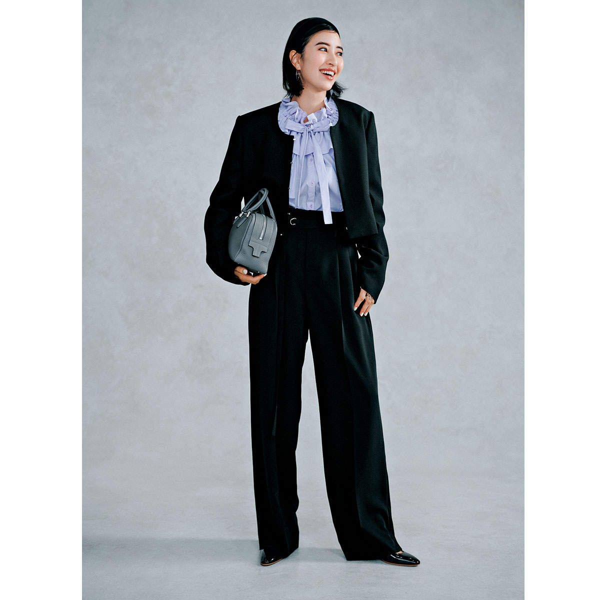 イウエンマトフのフリルブラウスにUネックのノーカラージャケットとパンツのセットアップを合わせたコーデ