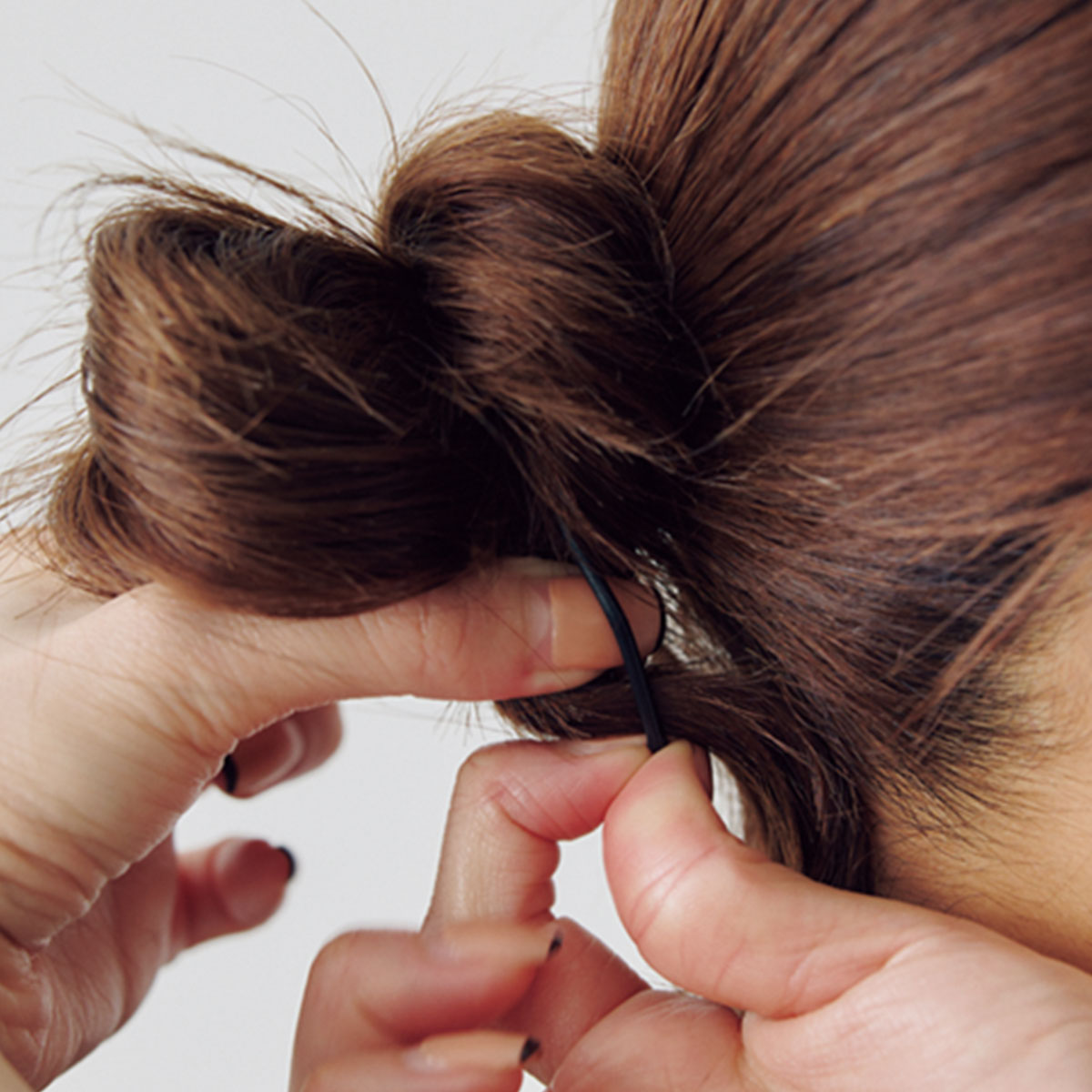 ベースのお団子に髪を巻き付けてゴムで結ぶ