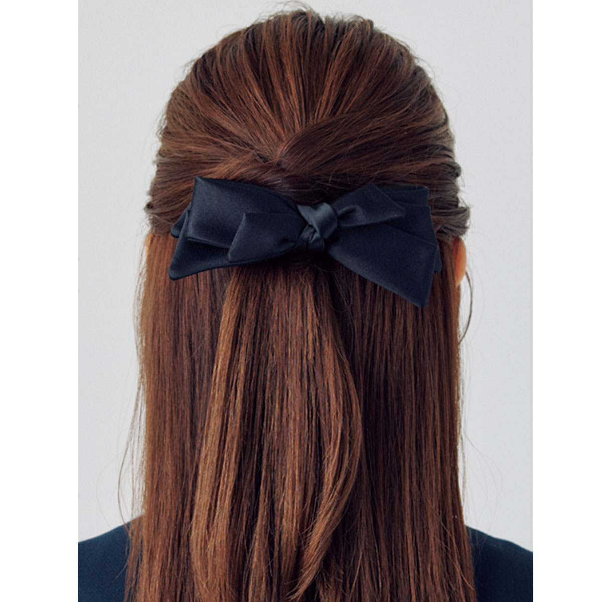 Wねじりを使ったハーフアップにリボンバレッタをつけた後ろ姿