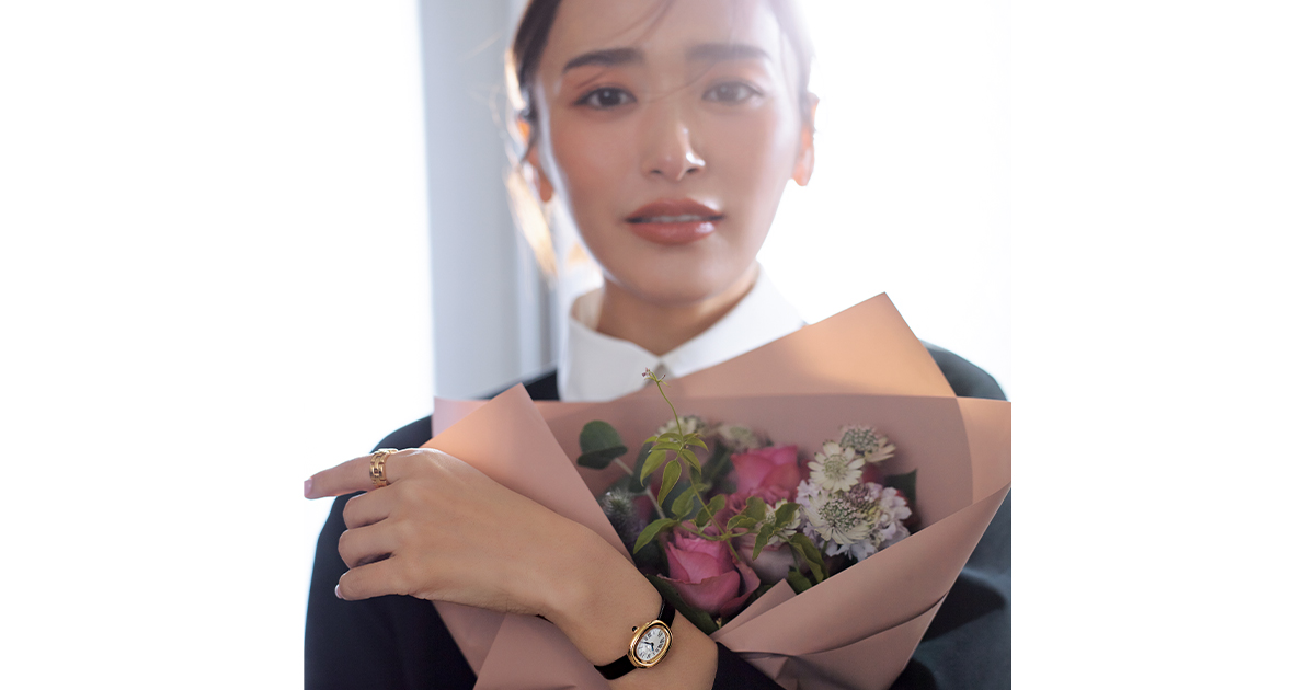 カルティエの腕時計ベニュワールを腕につけて花束を抱える近藤千尋さん