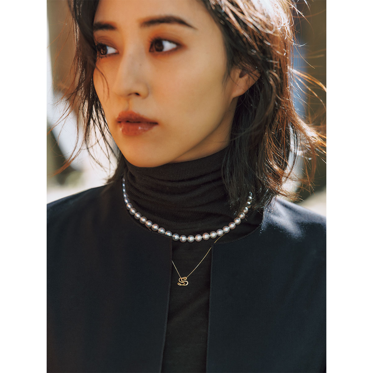 タートルニットの首元にパールのネックレスとシャルロット シェネのアルファベットネックレスを重ねづけした岡本あずささん