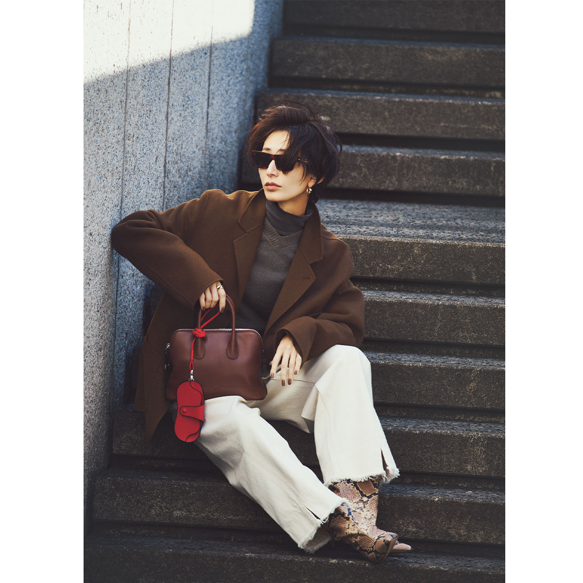 ニュアンスのあるグレーを濃淡でレイヤードしたトップスに白パンツを合わせたキレイめコーデ