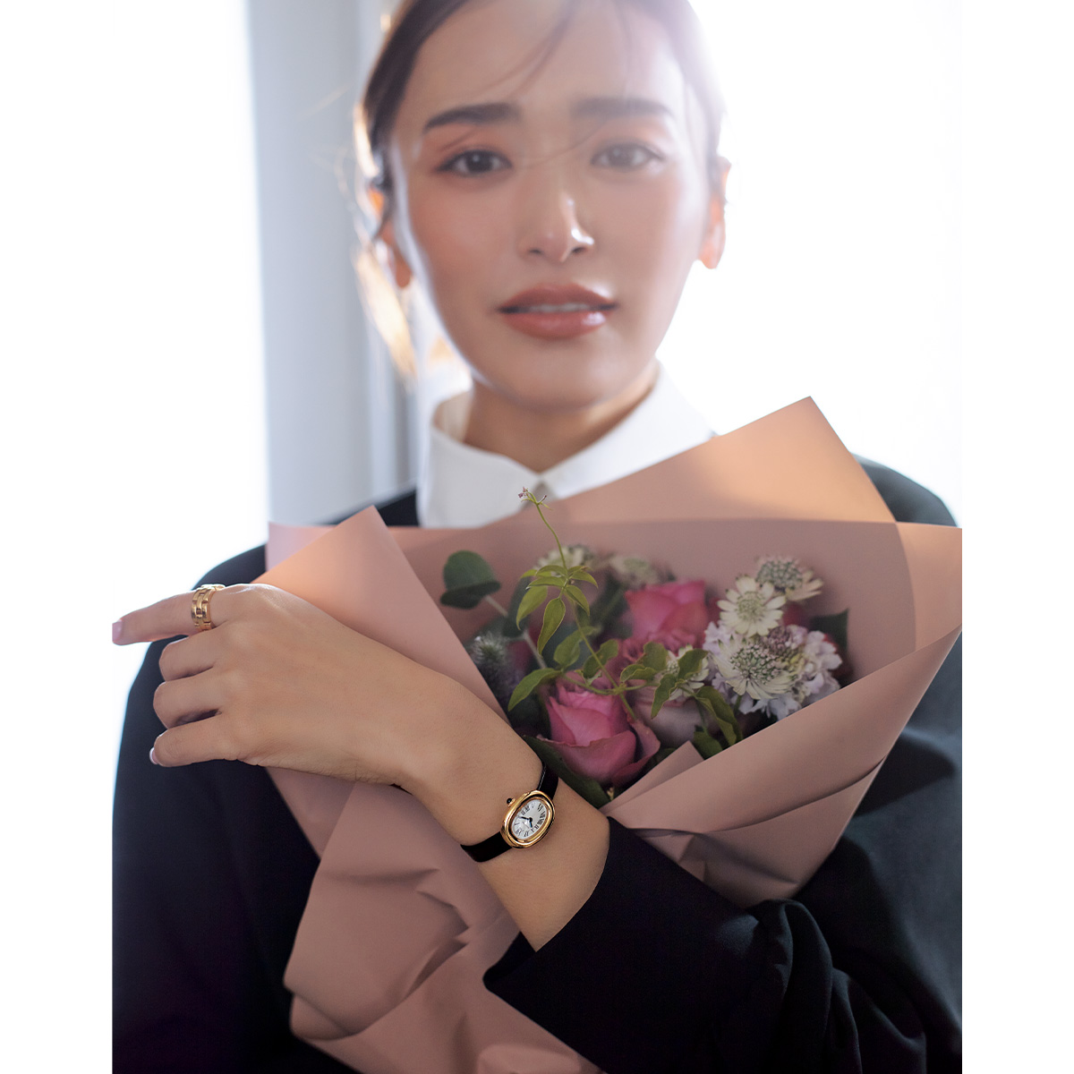 カルティエの腕時計ベニュワールを腕につけて花束を抱える近藤千尋さん