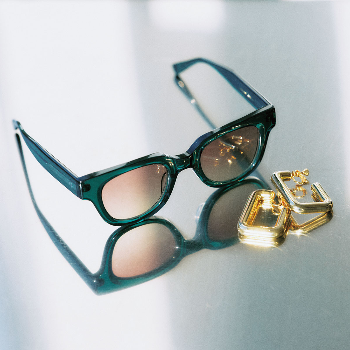 顔の余白を埋めるサングラスと大きめサイズのイヤリング