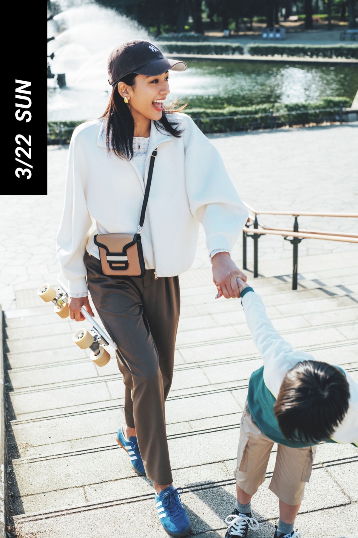 白のボンディングブルゾンにブラウンのパンツや小物とブルーのスニーカーを合わせた公園コーデ