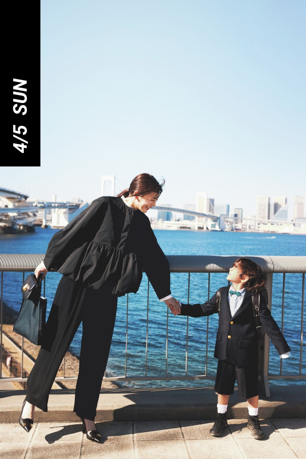 ペプラムデザインの甘めブルゾンと黒パンツの母行事コーデ