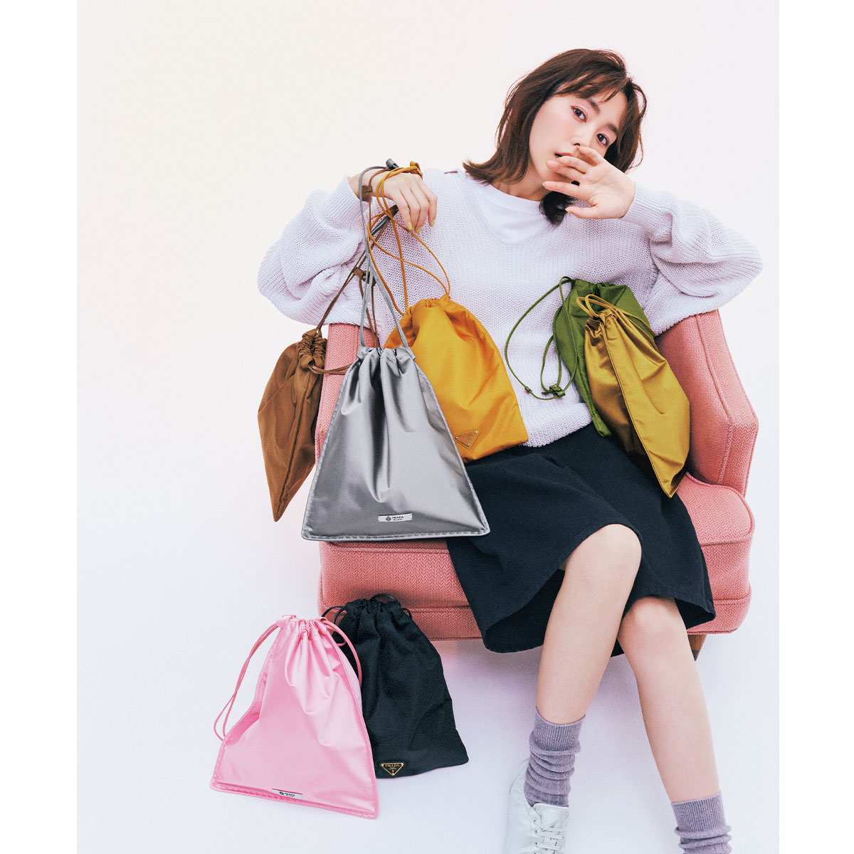 プラダのカラフルな巾着型ポーチバッグとそれを持つ桐谷美玲さん