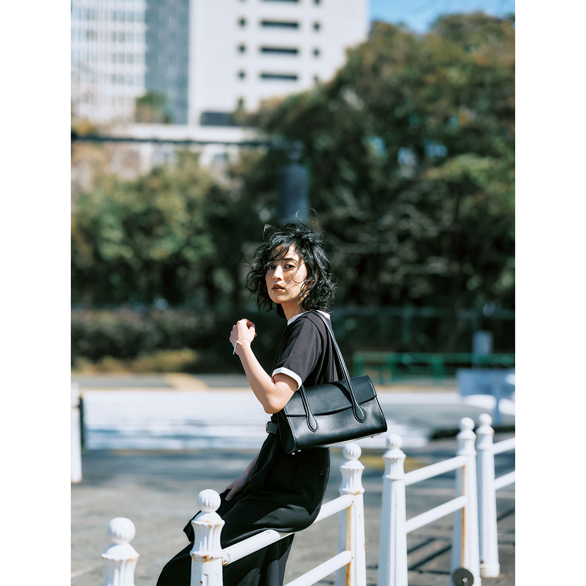 黒Tシャツとスカートにカロリーナ サント ドミンゴの黒バッグを肩かけした岡本あずささん