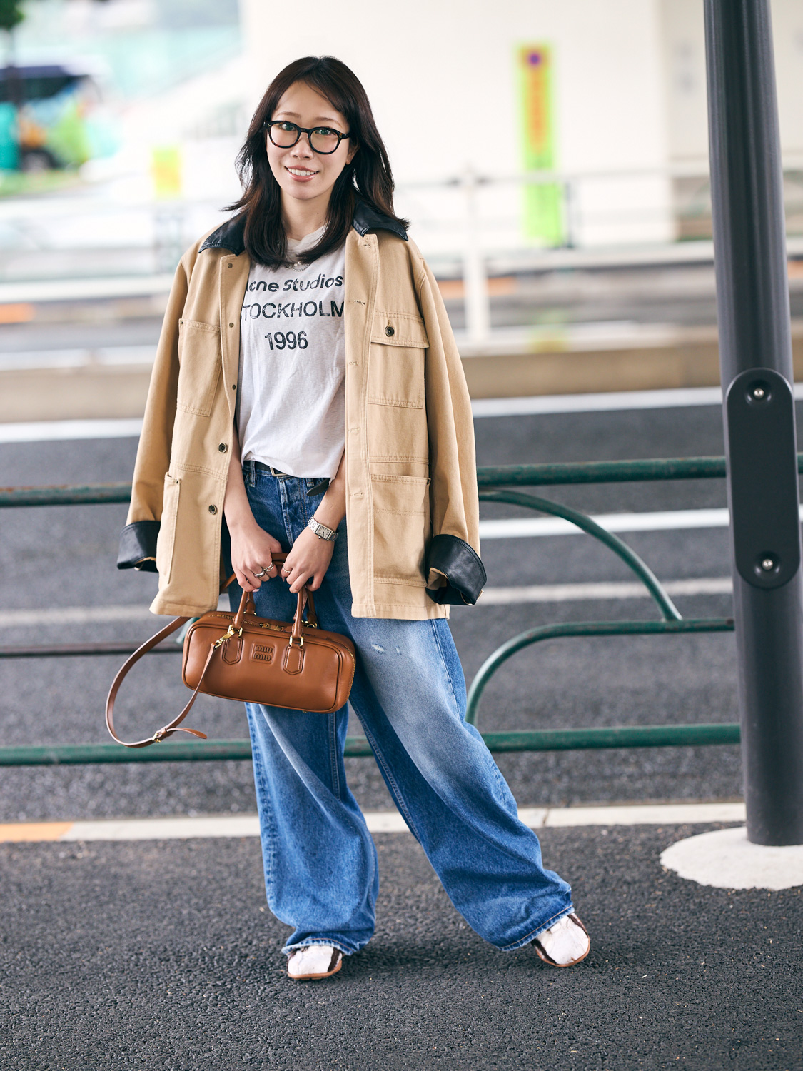 白いロゴTシャツ、ベージュのジャケット、デニムのコーディネート