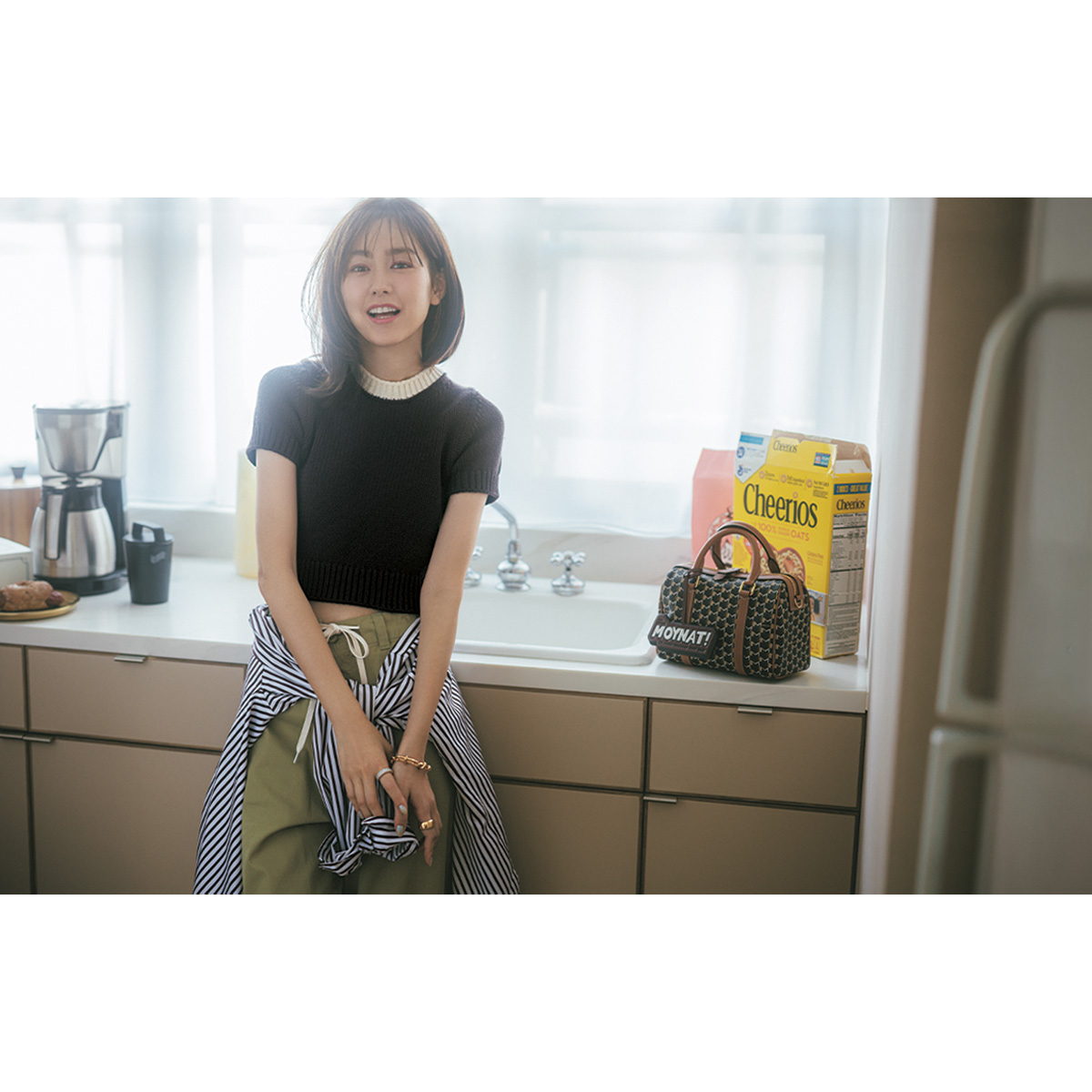 NKINITのちびTニットとチノパンにストライプ柄シャツを巻いた着こなし