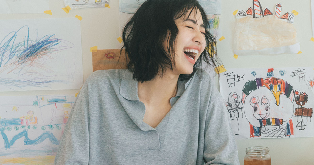 グレーのスキッパーポロニットを着た岡本あずささん