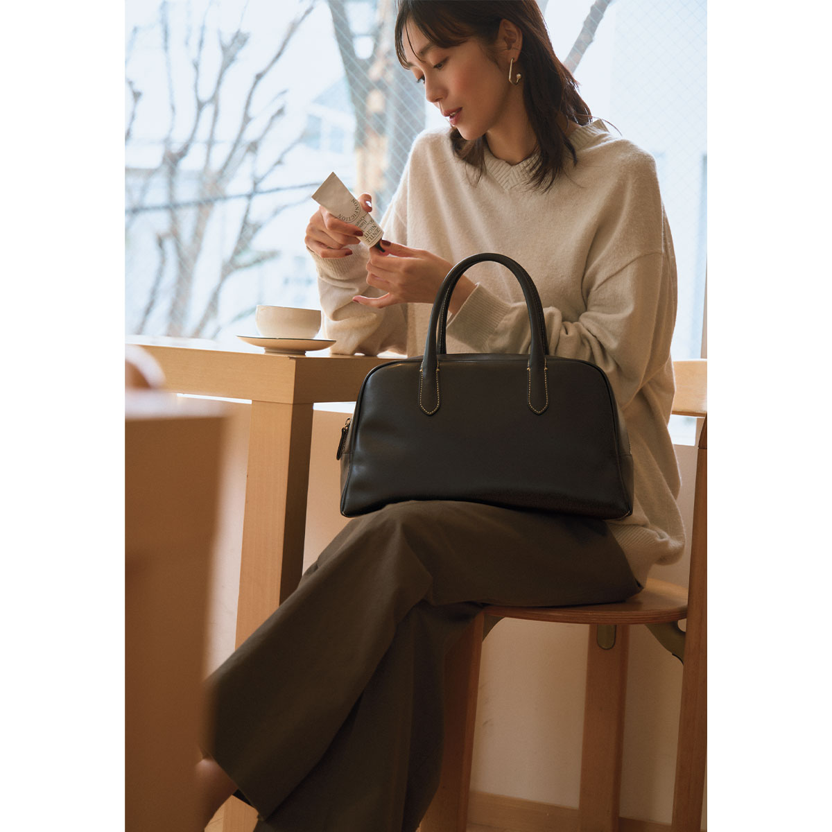 リネンニットとパンツコーデにナッシングリトゥンの名品クラシックゴルフバッグを合わせたコーデ